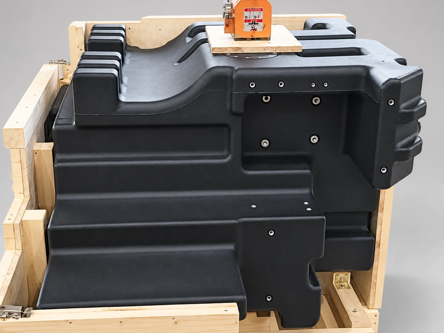Black ribbed molded tank on a wooden support